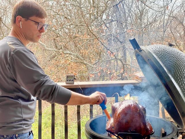 A member of The Grove KC community cooking outdoors.
